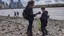 Photo of Femi Oriogun-Williams speaking with a young person by a river recording audio.